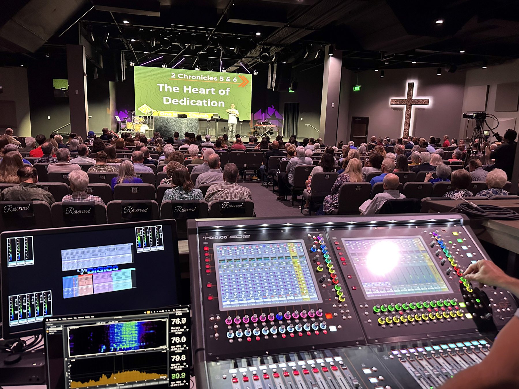 Congregation with mixing console and stage screens