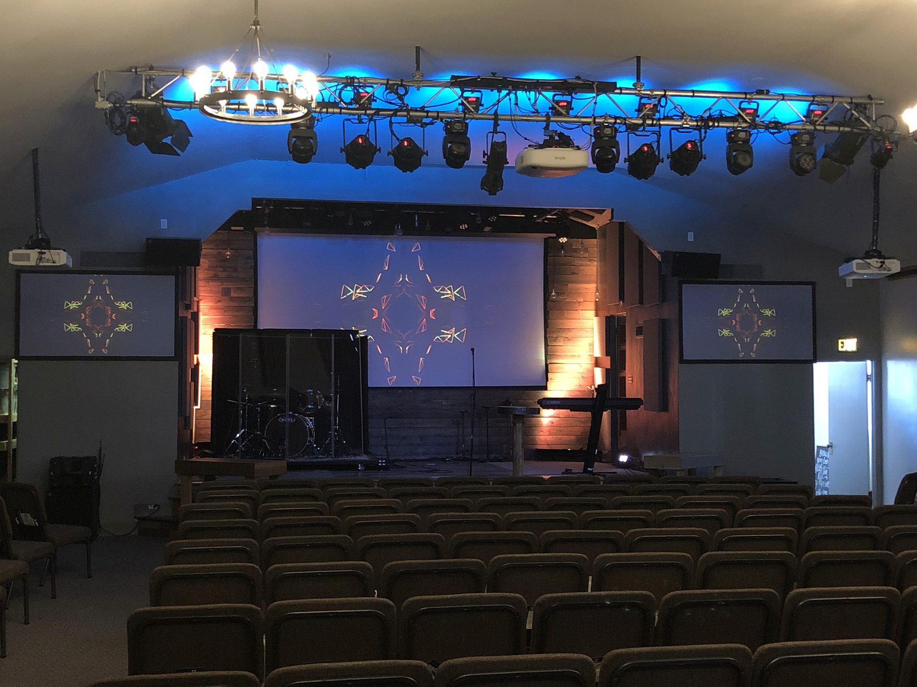 Blue-lit sanctuary stage with subwoofers and seating